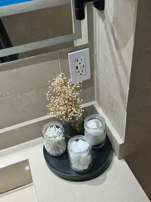 a black plate with three candles and a vase with flowers at Luxury Apartment Jacuzzi Air Conditioning Fireplace and King Bed in Medellín