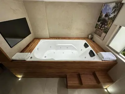 a jacuzzi tub in a bathroom with a window at Luxury Apartment Jacuzzi Air Conditioning Fireplace and King Bed in Medellín