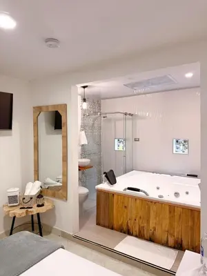 a large bathroom with a large tub and a toilet at Hostal Rose Moor in Jardin