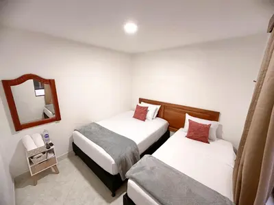 a hotel room with two beds and a mirror at Hostal Rose Moor in Jardin