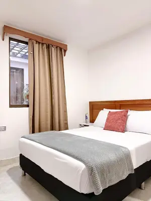 a bedroom with a large white bed and a window at Hostal Rose Moor in Jardin