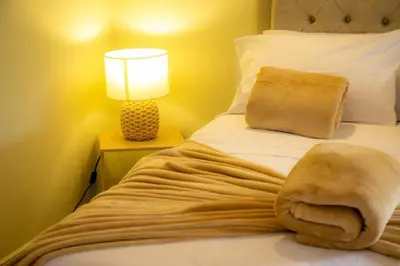 a bed with a blanket on it with a lamp at Loft para grupos parqueadero gratis LIRIO in Jardin