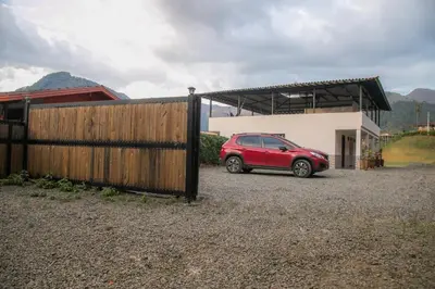 a red car parked in front of a house at Loft para grupos parqueadero gratis LIRIO in Jardin