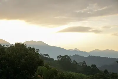 a view of a mountain range with the sun setting at Loft para grupos parqueadero gratis LIRIO in Jardin