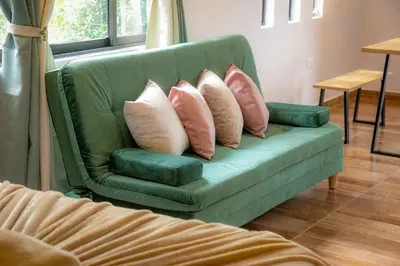 a green couch with four pillows on it at Loft para grupos parqueadero gratis LIRIO in Jardin