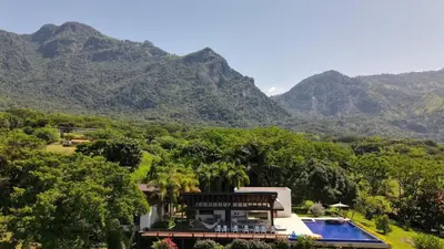 a house with a swimming pool and mountains in the background at Casa finca Pool & Jacuzzi, Tropical Oasis in Jericó