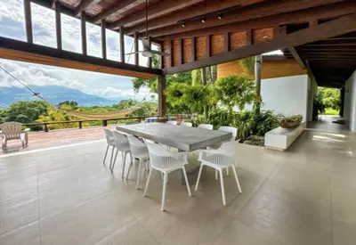 a dining room with a table and white chairs at Casa finca Pool & Jacuzzi, Tropical Oasis in Jericó