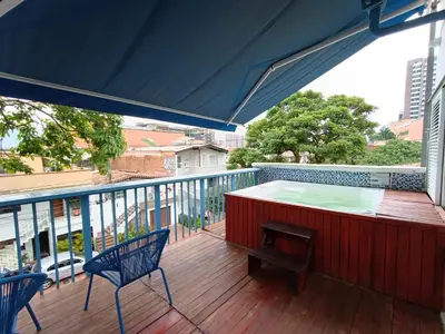 a deck with a table and chairs on a balcony at Habitación individual privada con baño privado y desayuno in Medellín