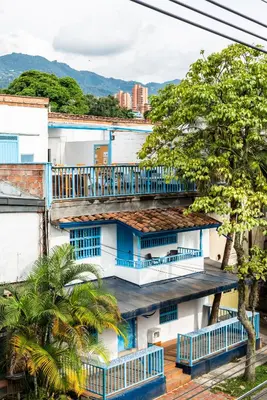 an apartment building with blue balconies and trees at Habitación individual privada con baño privado y desayuno in Medellín