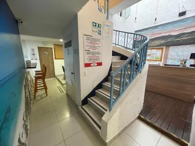 a staircase in a building with a sign on the wall at Habitación individual privada con baño privado y desayuno in Medellín