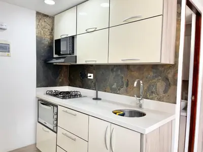 a kitchen with white cabinets and a sink at Modern furnished loft in el Poblado in Medellín