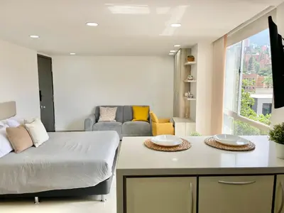 a living room with a bed and a couch at Modern furnished loft in el Poblado in Medellín