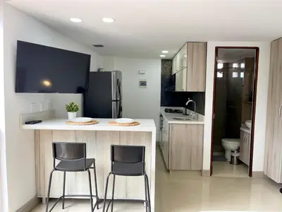 a kitchen with a counter and two bar stools at Modern furnished loft in el Poblado in Medellín