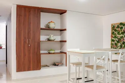 a dining room with a table and a wooden cabinet at Casa de las Flores en Medellín in Medellín