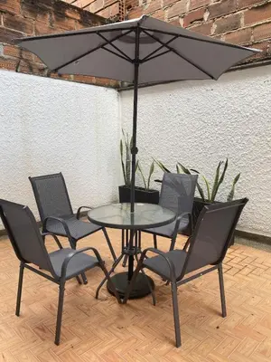 a table with four chairs and an umbrella at Casa de las Flores en Medellín in Medellín