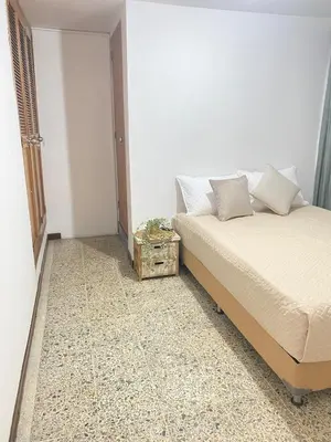 a small bedroom with a bed and a night stand at Casa de las Flores en Medellín in Medellín