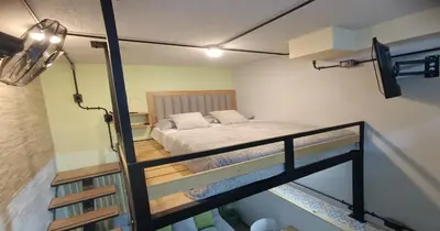 a small room with a bed and a staircase at Zen Hausinn Cozy Studio - Poblado Medellin in Medellín