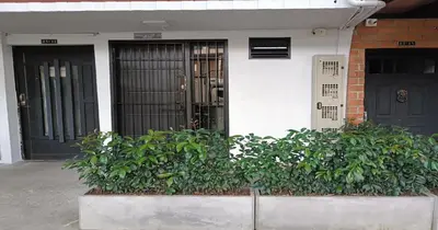 a house with two black doors and some bushes at Zen Hausinn Cozy Studio - Poblado Medellin in Medellín