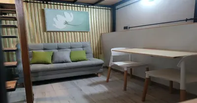 a couch with two green pillows in a room at Zen Hausinn Cozy Studio - Poblado Medellin in Medellín