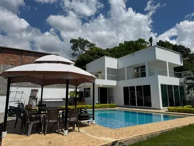 a villa with a swimming pool and an umbrella at Paraíso in San Jerónimo