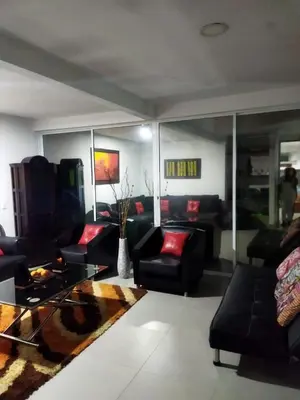 a living room with black furniture and red pillows at Paraíso in San Jerónimo