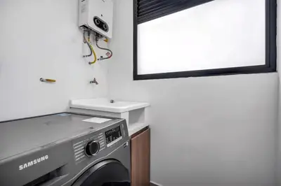 a kitchen with a washing machine and a mirror at Poblado, 5 min to San Lucas Plaza, Free parking 315 in Medellín