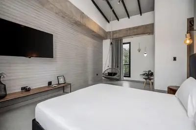 a bedroom with a white bed and a flat screen tv at Poblado, 5 min to San Lucas Plaza, Free parking 315 in Medellín