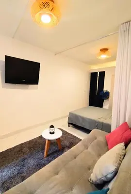 a living room with a couch and a tv at Laureles estadio plaza mayor la 70 unicentro in Medellín