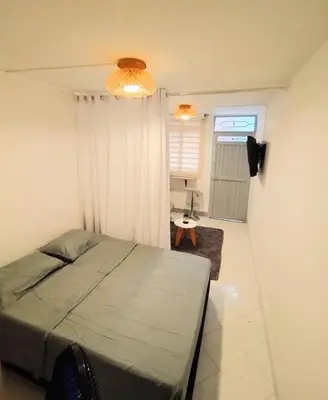 a bedroom with a bed and a table in a room at Laureles estadio plaza mayor la 70 unicentro in Medellín