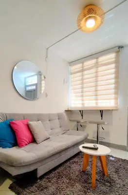 a living room with a couch and a mirror at Laureles estadio plaza mayor la 70 unicentro in Medellín