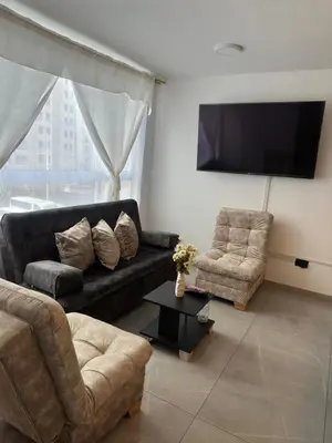 a living room with a black couch and two chairs at Apartamento familiar y agradable in Manizales