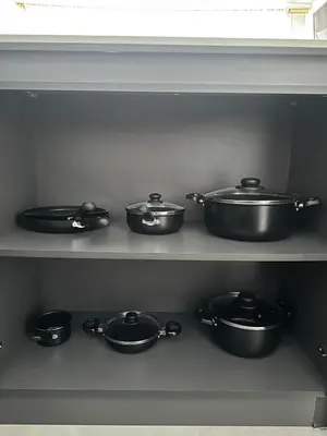 a row of pots and pans on a shelf at Apartamento familiar y agradable in Manizales