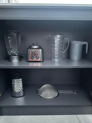 a shelf with a blender and a clock and cups at Apartamento familiar y agradable in Manizales
