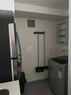 a small kitchen with a refrigerator and a sink at Apartamento familiar y agradable in Manizales