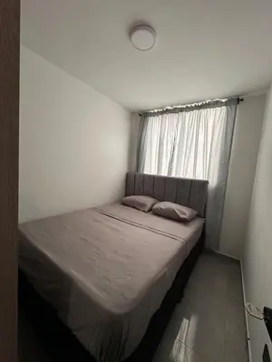a bed in a small room with a window at Apartamento familiar y agradable in Manizales