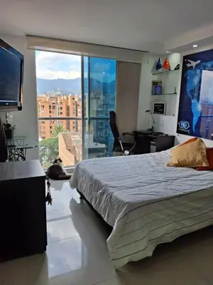 a bedroom with a large bed and a large window at RentalsOP AN09 Apartamento en Laureles el barrio mas cool del mundo, moderno, con balcon y excelente vista in Medellín