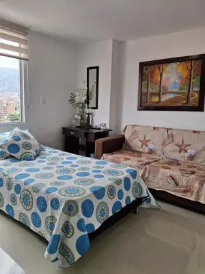 a bedroom with a bed and a couch at RentalsOP AN09 Apartamento en Laureles el barrio mas cool del mundo, moderno, con balcon y excelente vista in Medellín