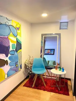 a room with a table and two chairs and a painting at Tu hogar temporal en Medellín, Moderno, cómodo, bien ubicado y WIFI 400 in Medellín