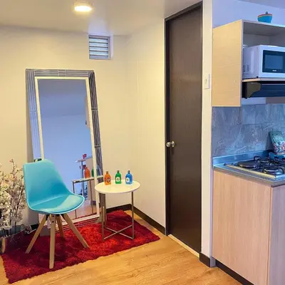 a small kitchen with a table and a blue chair at Tu hogar temporal en Medellín, Moderno, cómodo, bien ubicado y WIFI 400 in Medellín
