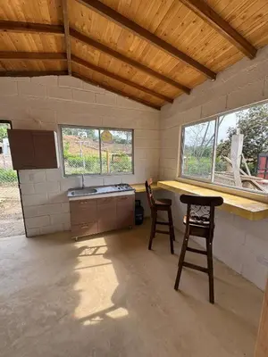 a kitchen with two stools and a counter and two windows at Mariposa 1 in Sopetran