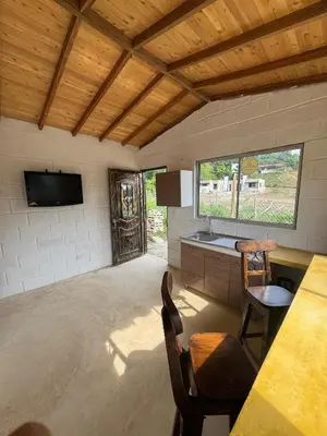 a room with a table and chairs and a television at Mariposa 1 in Sopetran
