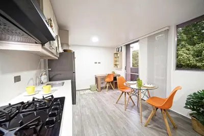 a kitchen with a stove and a table with chairs at Diseño único y encanto en un barrio tranquilo, in Medellín