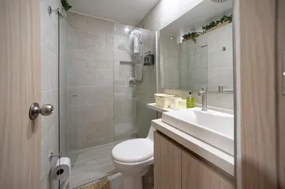 a bathroom with a toilet and a sink and a shower at Diseño único y encanto en un barrio tranquilo, in Medellín