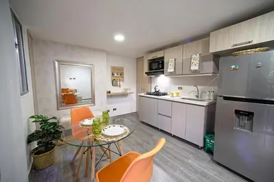 a kitchen with a table and chairs in a room at Diseño único y encanto en un barrio tranquilo, in Medellín