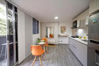 a kitchen with orange chairs and a table in it at Diseño único y encanto en un barrio tranquilo, in Medellín