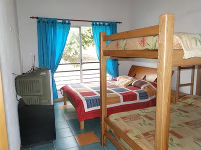 a bedroom with two bunk beds and a television at Hotel Familiar El Remanso Del Agua in Guatapé