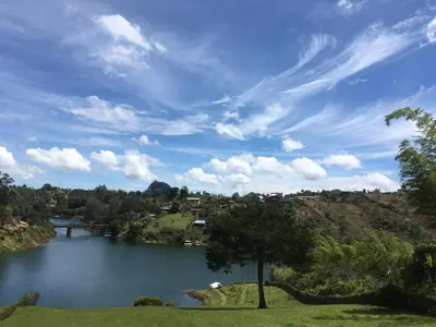 a view of a river with a bridge on a hill at Hotel Familiar El Remanso Del Agua in Guatapé