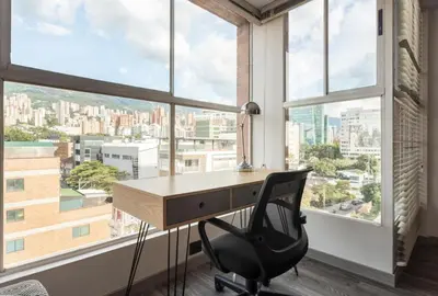 an office with a desk and a chair in front of a window at Edificio Casa Roma by Host Medellin in Medellín