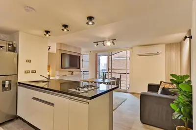 an open kitchen with a stove and a couch at Edificio Casa Roma by Host Medellin in Medellín