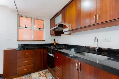 a kitchen with wooden cabinets and a sink at Edificio Casa Roma by Host Medellin in Medellín